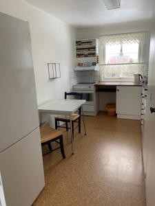 eine Küche mit weißen Geräten und einem Tisch darin in der Unterkunft Four Bedroom Guesthouse in Fjerdingen, Harran in Grong