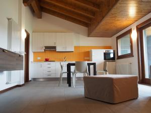 una cucina con armadi bianchi e tavolo con sedie di Alloggio Agrituristico Ai Tre Castelli a Moruzzo