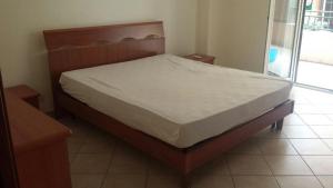 a bed in a bedroom with a wooden headboard at Casa degli Oleandri in Roccalumera