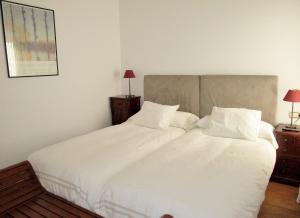 1 dormitorio con 2 camas con sábanas y almohadas blancas en bt6sevilla, en Sevilla