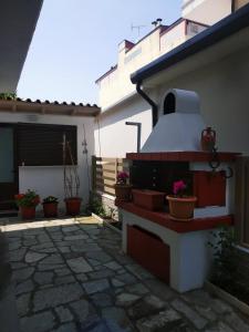 eine Terrasse mit Topfpflanzen an der Seite eines Hauses in der Unterkunft Dimitra's Apartments in Olympiakí Aktí