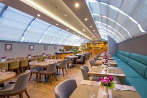 un restaurante con mesas y sillas y un tragaluz grande en Tbilisi Chambers, Trademark Collection by Wyndham, en Tiflis