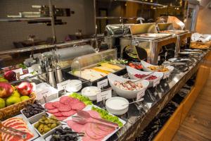 Una línea de buffet con muchos tipos diferentes de comida. en Tbilisi Chambers, Trademark Collection by Wyndham, en Tiflis