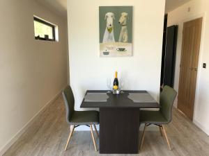 a dining room with a black table and chairs at Parkknott Retreat Luxury Lodge with Private Hot Tub in Askam in Furness