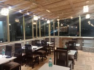 a dining room with tables and chairs and windows at Hotel Shivaay Grand in Amritsar
