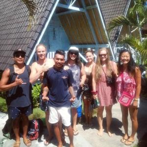 a group of people standing in front of a house at D'Yuki Huts Lembongan in Nusa Lembongan