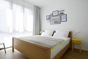 ハイリゲンハーフェンにあるHeiligenhafenkojeのベッドルーム1室(白い壁のベッド1台、窓付)