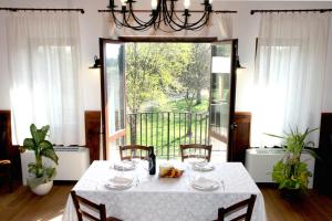 une salle à manger avec une table et une grande fenêtre dans l'établissement Agriturismo Le Giarine, à Fogliano Redipúglia
