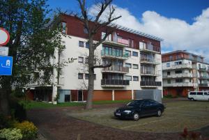 een auto geparkeerd op een parkeerplaats voor een gebouw bij HelApart - Helska Villa in Hel