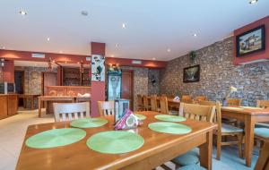 a dining room with a wooden table with green plates on it at Family Hotel LILI in Bansko +32 photos