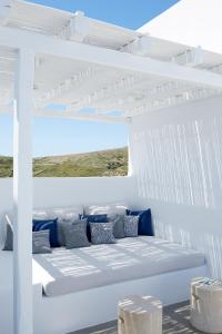 a white bench in a white room with a window at Milos Breeze Boutique Hotel in Pollonia