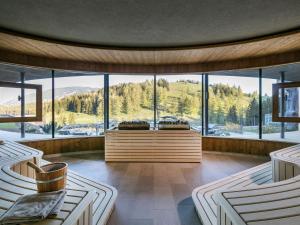 a room with a large window with a view of the mountains at Almwellness Hotel Pierer in Fladnitz an der Teichalm