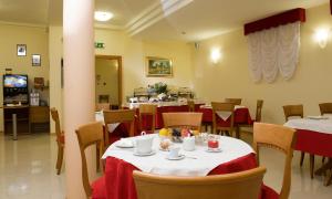 a restaurant with tables and chairs with red table cloth at Hotel Montereale in Pordenone