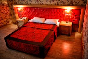 - une chambre avec un lit rouge et 2 tables de chevet dans l'établissement Anemon Antakya Hotel, à Hatay