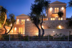 a house with a wall and trees in front of it at Villa Dinos in Tranakatika