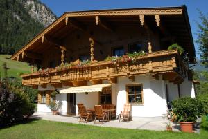 een huis met een balkon met een tafel en stoelen bij Appartement Gredler Martina in Mayrhofen