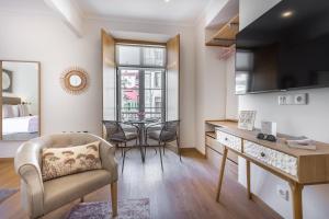 een woonkamer met een tafel en een stoel in een kamer bij With You Suites in Lissabon