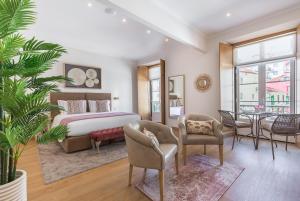 een slaapkamer met een bed en een tafel en stoelen bij With You Suites in Lissabon