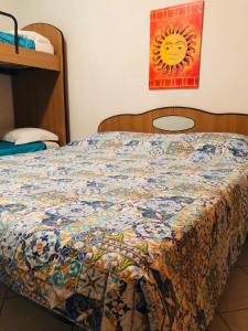 ポルトパーロにあるCamping Residence Capo Passeroのベッドルームに掛け布団付きのベッド1台