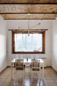 LaVistaDeiSogni Palmarette في تشلانو: غرفة طعام مع طاولة بيضاء وكراسي ونافذة
