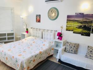 a bedroom with a bed and a clock on the wall at La Dolce Vita studio with free private parking in Siena