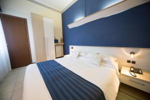 ein Schlafzimmer mit einem großen Bett und einer blauen Wand in der Unterkunft Hotel Villa Igea in Diano Marina