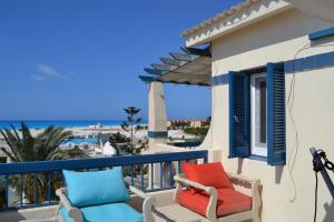 balcón con 2 sillas y vistas al océano en La Stanza Chalet, en Dawwār ‘Abd al ‘Aţī Abū ‘Ajūz