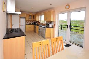 a kitchen with yellow cabinets and a table and chairs at Cottage 102 - Ballyconneely in Ballyconneely