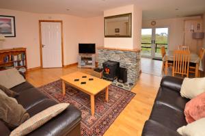 a living room with a couch and a fireplace at Cottage 102 - Ballyconneely in Ballyconneely