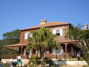 a house with a palm tree in front of it at Pousada Avalon Paranapiacaba in Paranapiacaba