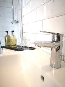 a bathroom sink with a soap dispenser on a counter at Mode Hotel Lytham in Lytham St Annes