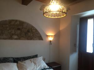 a bedroom with a bed and a chandelier at La Taverna @ Casale Corneto in Bomba
