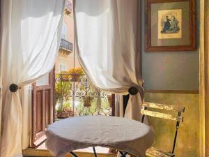 einen Stuhl vor einem Fenster mit Vorhängen in der Unterkunft Il Salotto di Maria Pia in Syrakus