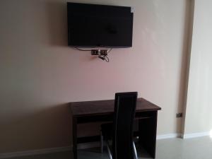 a desk with a chair and a television on a wall at Hotel Astore Suites in Antofagasta