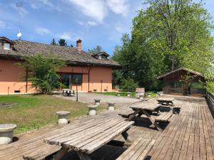 a picnic table and benches on a wooden deck at Villa Bonelli Bed & Fest in Savigliano
