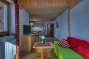 a living room with a green couch and a table at Ferien-Schlössle Michaela in Riezlern