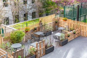 a patio with tables and plants in a garden at ibis budget Paris Porte de Vincennes in Paris
