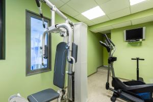 a gym with green walls and a treadmill at ibis budget Paris Porte de Vincennes in Paris