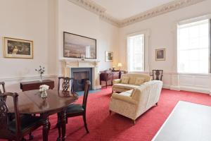 uma sala de estar com uma mesa e cadeiras e uma lareira em Henrietta Suites City Centre em Dublin