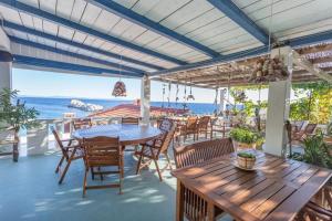 a patio with tables and chairs and the ocean at Robinson Elizabeta in Hvar