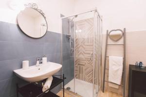 un bagno con lavandino e doccia di Residenza Macos a Siracusa
