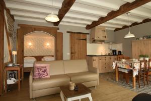 ein Wohnzimmer mit einem Sofa und einer Küche in der Unterkunft Hof Kricheleberg in Bocholtz