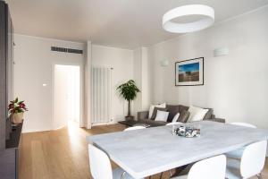 un soggiorno bianco con tavolo e divano di Brand new apt , City Life district a Milano