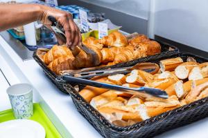 a person reaching for a tray of croissants at ibis budget Paris Porte de Vincennes in Paris