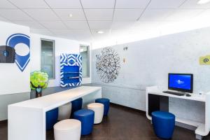 an office with blue stools and a desk with a computer at ibis budget Paris Porte de Vincennes in Paris