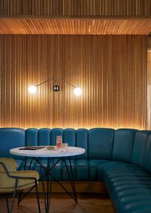 a dining room with a blue couch and a table at PURO Łódź Centrum in Łódź