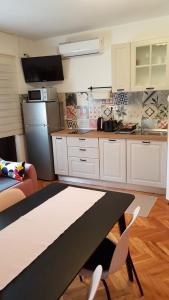 a kitchen with a table and chairs and a refrigerator at Villa Lykos Plitvice in Plitvička Jezera +33 photos