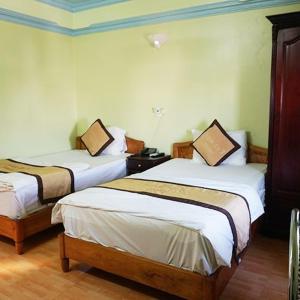 una camera d'albergo con due letti e una lampada di KHÁCH SẠN NGỌC LY 2 a Thanh Hóa