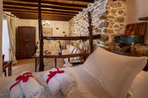 Schlafzimmer mit einem Bett mit weißer Bettwäsche und roten Bögen in der Unterkunft Fimaira in Ermoupoli