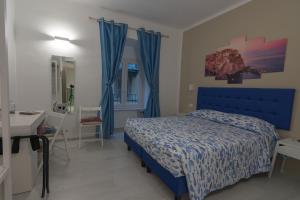 1 dormitorio con cama azul y escritorio en Ca' da Sirio en La Spezia